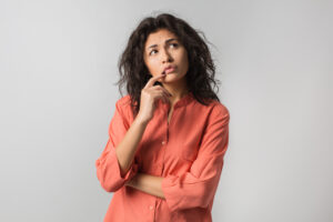 pretty-young-woman-thinking-about-problem-confused-emotion-isolated-wearing-orange-shirt-hipster-style-curly-hair-holding-finger-lips-looking-up-having-idea-300x200 Qual faculdade escolher? Descubra como escolher um curso de faculdade